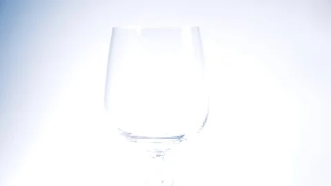 Beer being poured into translucent glass, white isolated background,  Stock Footage 77859385