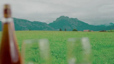 Beer Bottle and Glasses on Alpine Meadow, Mountain Panorama, Wide Shot Vídeo Stock 341451914