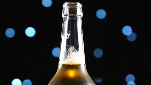 Beer bottle close-up. Light beer in bottle rotated over black background. Stock Footage 112676143