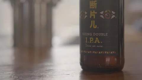 Beer Bottle Close-Up on Wooden Table in Beijing Indoor Food and Drink Scene Stock Footage 345755951