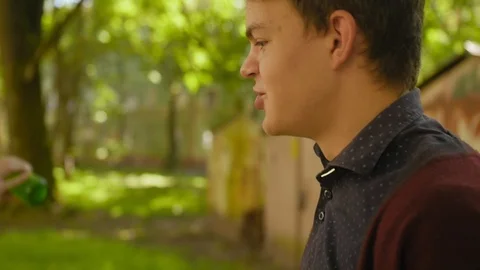 Beer bottle close up. Young guy talking and drinking beer from a bottle Stock Footage 118546642