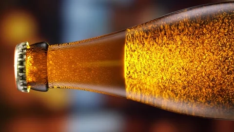 Beer bottle featuring lively bubbles and frothy foam, bar counter in background Stock Footage 275987628
