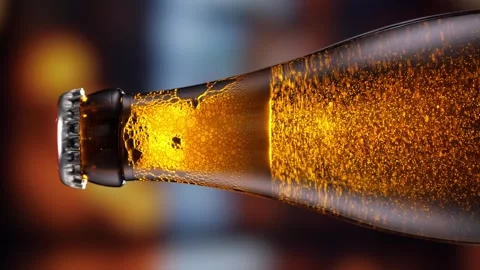 Beer bottle featuring lively bubbles and frothy foam, bar counter in background Stock Footage 279485715