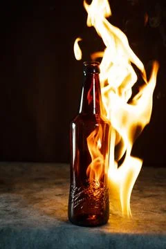 Beer bottle in fire and flame Stock Photos
