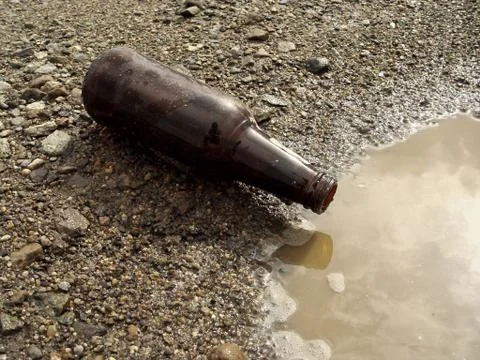 Beer bottle on ground Stock Photos