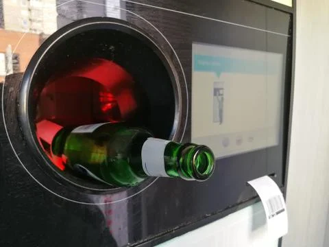 Beer bottle inserted in the automatic reverse vending machine for recycling Foto stock