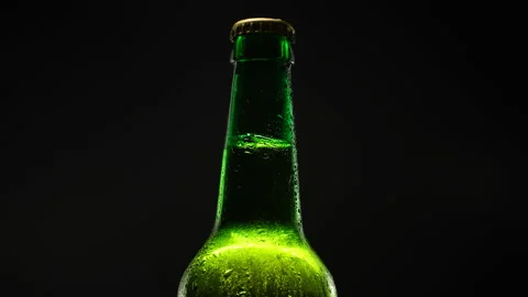 Beer bottle rotating against dark background. Stock Footage 153664312
