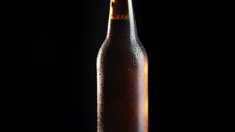 Beer bottle rotating on black background Stock Footage 132560839