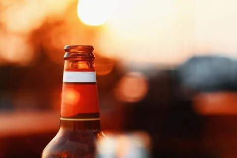 Beer Bottle At Sunset On Blurred Background With Lens Flare Stock Photos