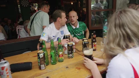 Beer bottles on a bar table as fans drink Stock Footage 345278435