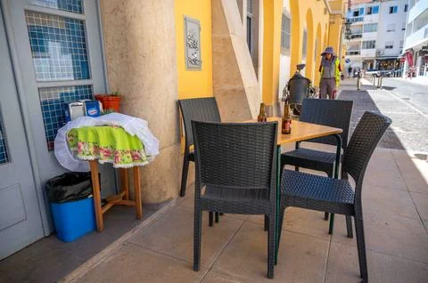Beer bottles on empty table chairs outdoorcafe quaint Algarve village scene Foto stock