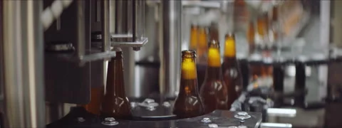 Beer bottles getting filled and capped Stock Footage 147373105