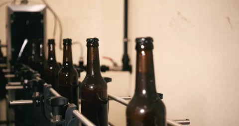 Beer bottles moving on automated conveyor belt in industrial brewery Berlin Stock Footage 335142904