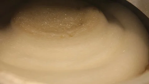 Beer is brewed and fermented in large aluminum tanks. Foam on the surface. Stock Footage 113523984