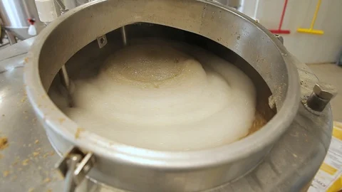 Beer is brewed and fermented in large aluminum tanks. Foam on the surface. Stock Footage 113524055