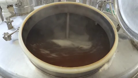 Beer is brewed and fermented in large aluminum tanks. Foam on the surface. Close Stock Footage 149661540