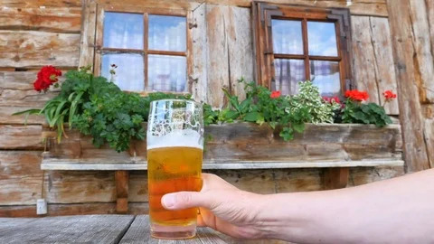 Beer drinking in front of mountain hut Video stock 77604634