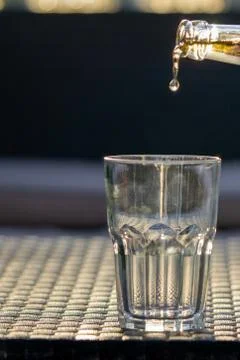 Beer drop falling down to the glass. Stock Photos