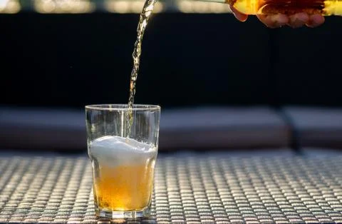 Beer drop falling down to the glass. Stock Photos