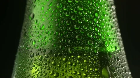 Beer drop slowly trickles down the misted beer bottle, following the camera Video stock 201338552