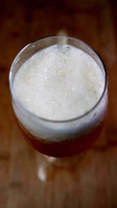 Beer drops fall slowly into a glass. Zoom-in: someone pouring a glass of beer Vídeo Stock 345099704