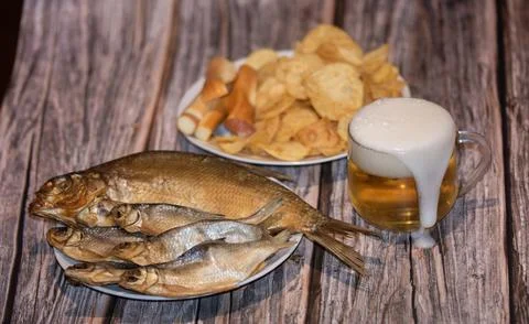Beer foam flows chips and chechil cheese on the table Foto stock