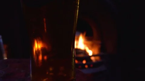 Beer in front of a fire in a pub. Slow Motion Stock Footage 85479863