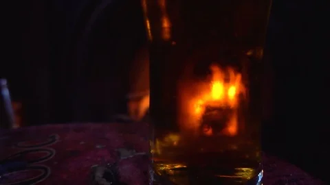 Beer in front of a fire in a pub. Slow Motion Stock Footage