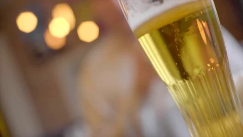 Beer glass with clinking glasses on the background out of focus Stock Footage 72622017