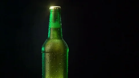 Beer in a green bottle rotating on a black background. Stock Footage 77094392