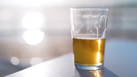 Beer half empty or half full with people passing in blurry background Stock Footage 277206682