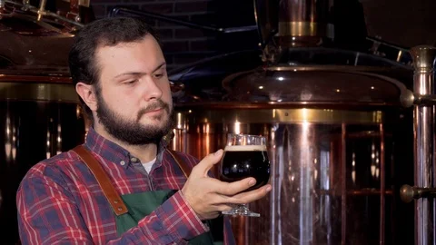 Beer maker drinking delicious dark beer, smiling to the camera Stock Footage 103049546
