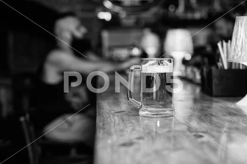 Beer mug on bar counter defocused background. Glass with fresh lager draft beer Stock Photos