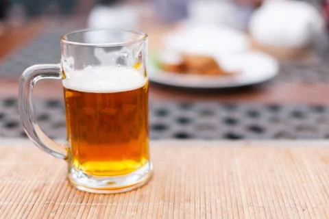 Beer mug with beer on a table outside Foto stock