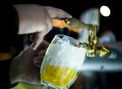 Beer is poured from behind the bar Stock Photos