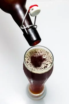 Beer is pouring from a bottle Stock Photos