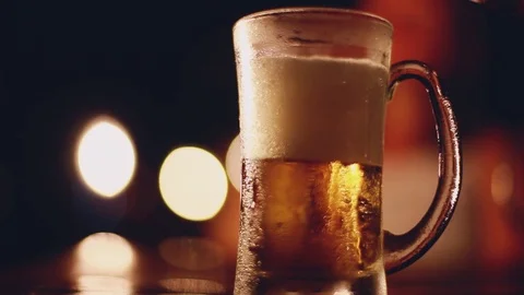 Beer pouring into glass from the Bottle. Glass of beer on the table with Stock Footage