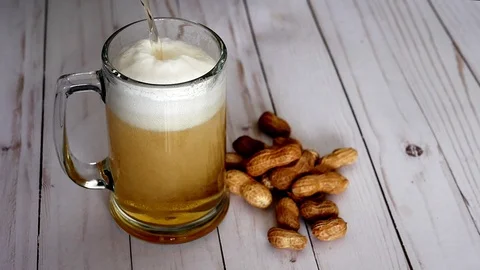 Beer pouring into mug and peanuts Stock Footage 97730049