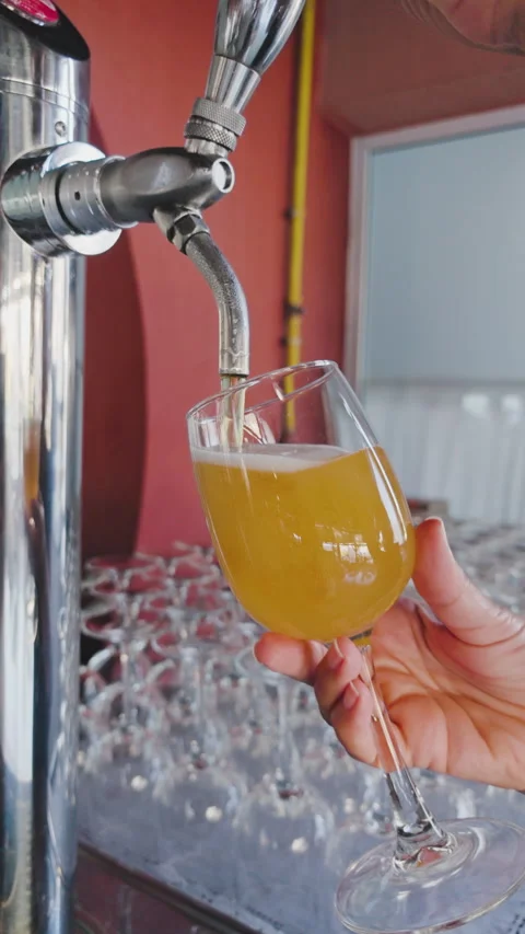 Beer pouring from a professional draft tap into a clear glass at a pub. Stock-Footage 343940441