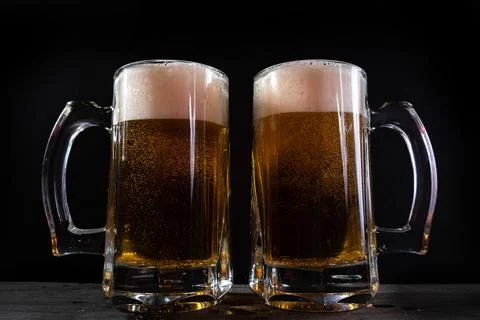 Beer pourson black background. Stock Photos