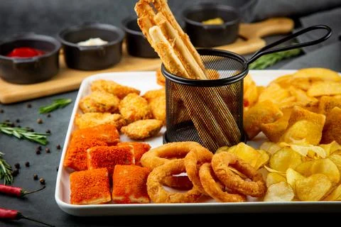 Beer set with nuggets, breaded onion rings, fries and sauces side view Stock Photos
