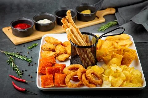 Beer set with nuggets, breaded onion rings, fries and sauces side view Stock Photos