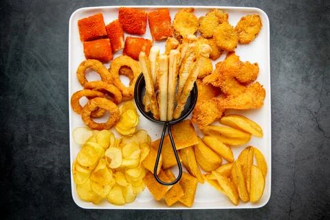 Beer set with nuggets, breaded onion rings, fries and sauces top view Stock Photos