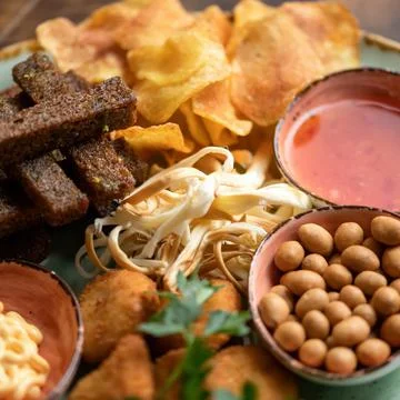 Beer snack. Nuts, black bread croutons, potato chips and smoked cheese on Stock Photos