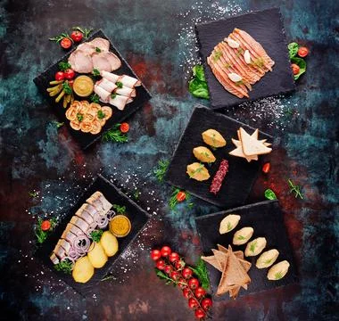 Beer snacks. Assorted meat plates with slices of bacon, ham, meat rolls and Stock Photos