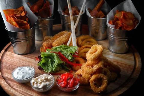 Beer snacks. chips, squid rings, croutons and nuggets, with sauces Stock Photos
