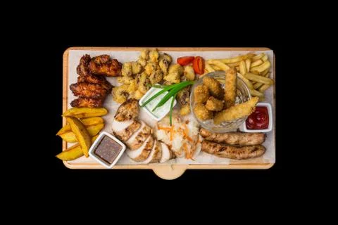 Beer snacks set. Chicken snacks served on cutting board, isolated on the black Stock Photos