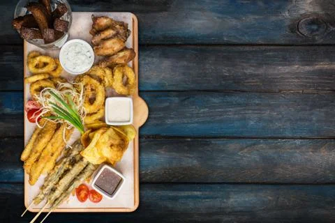 Beer snacks set. Fish set served on cutting board with the mugs, on the wooden Stock Photos
