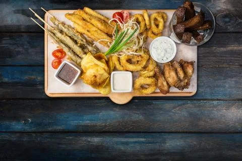 Beer snacks set. Fish set served on cutting board with the mugs, on the wooden Stock Photos