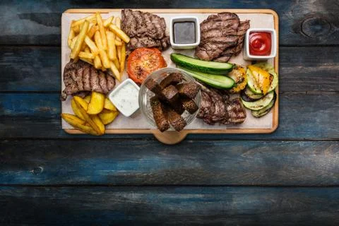 Beer snacks set. Meat set served on cutting board with the wooden background. Stock Photos